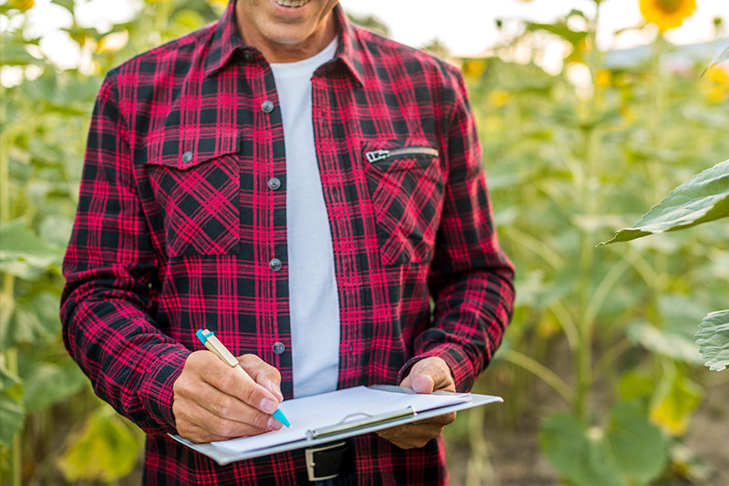 Persona tomando notas en medio del campo